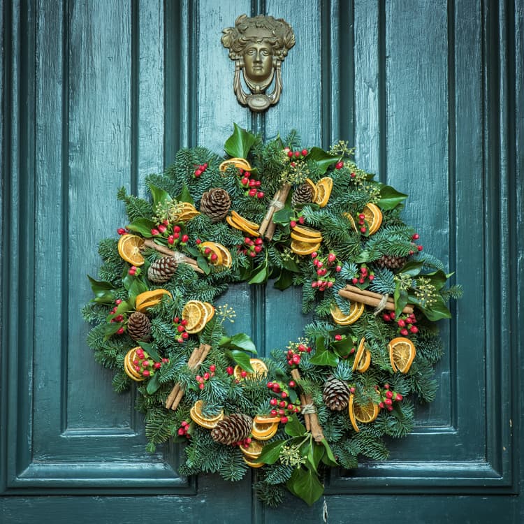 A green door with a wreath on it