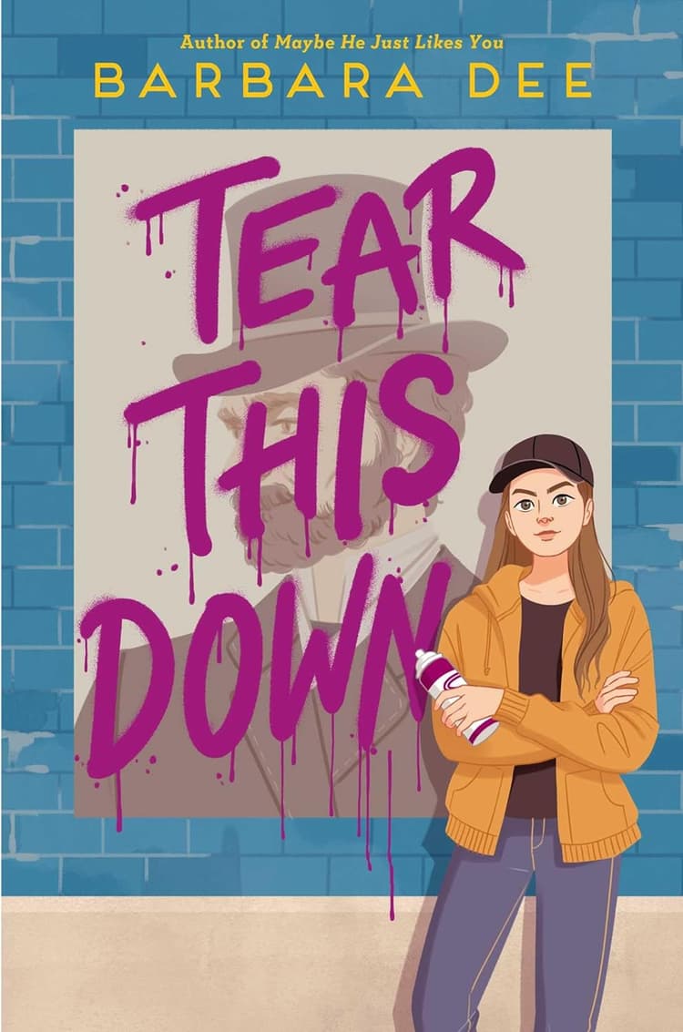 A woman standing in front of a poster with the words tear this down