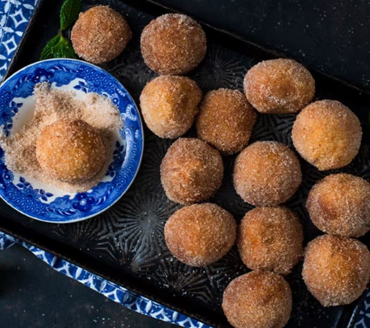 A blue and white tray filled with sugar covered donuts