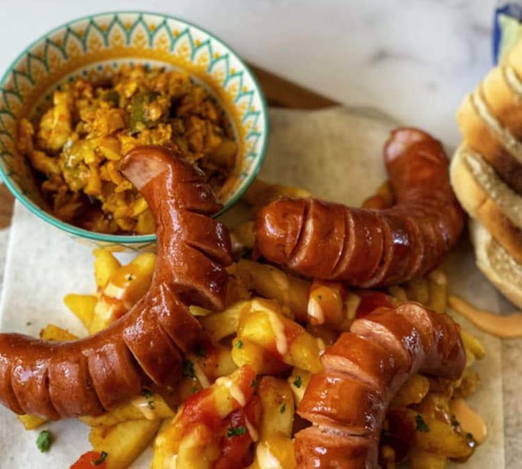 A plate of hot dogs and a bowl of macaroni and cheese