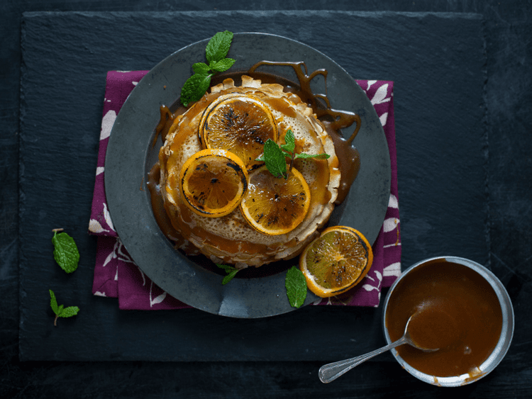 A plate of food with oranges and a cup of tea