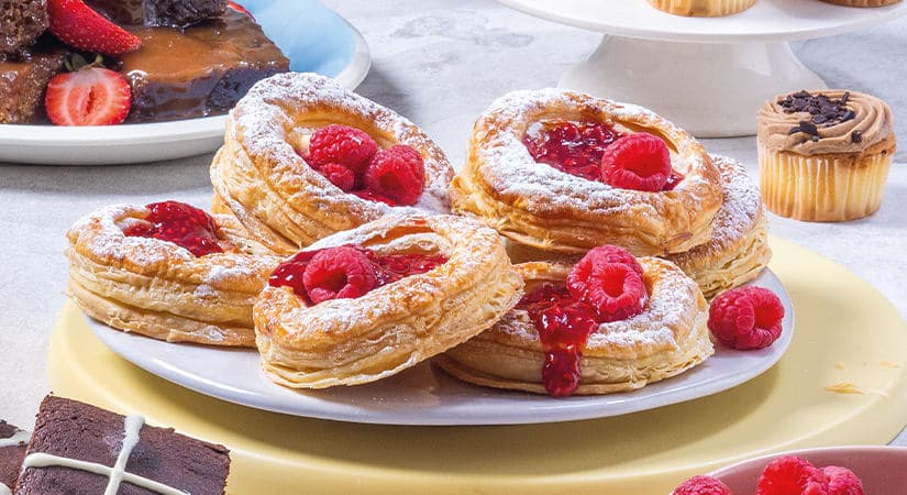 A table topped with plates of pastries covered in powdered sugar