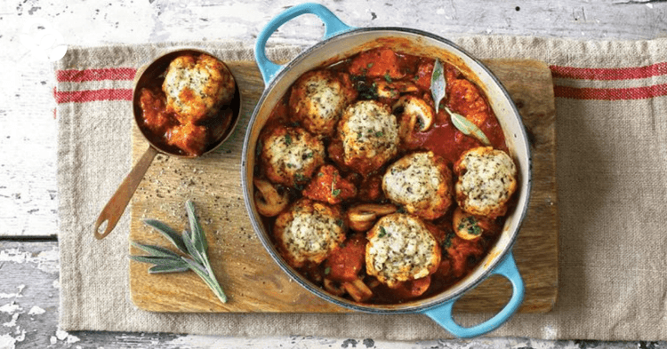 A pot of meatballs with tomato sauce and herbs