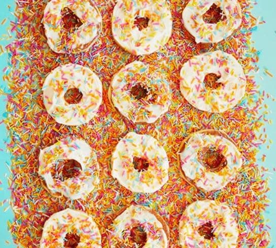 A group of doughnuts with sprinkles on a blue background